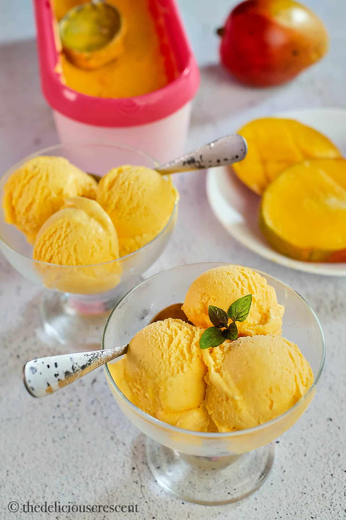 Scoops of mango gelato in glass bowls.