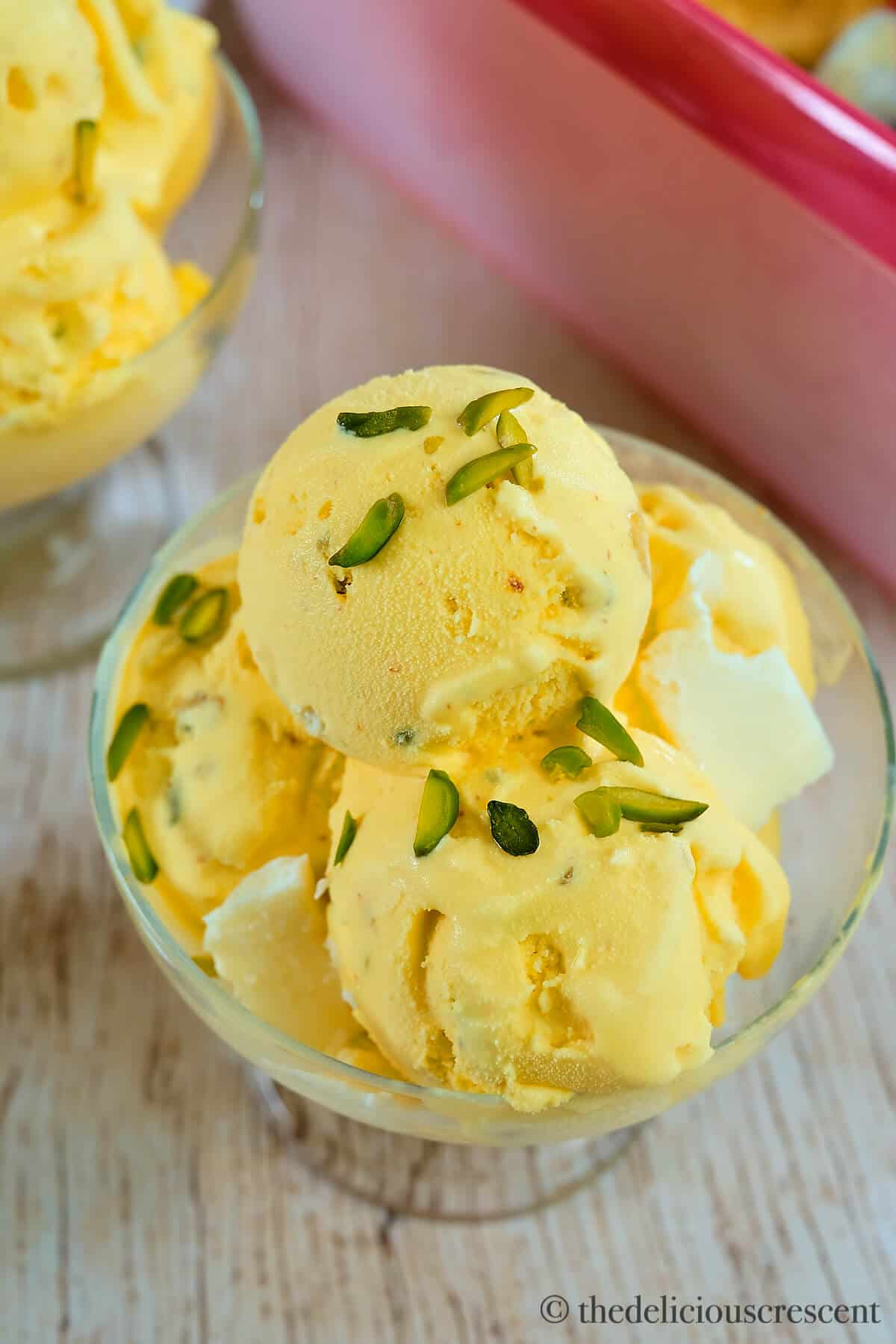 Saffron ice cream in a glass bowl.