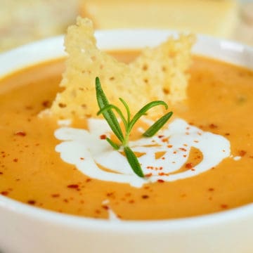 Close up view of sweet potato soup made with coconut milk and topped with parmesan crisps.