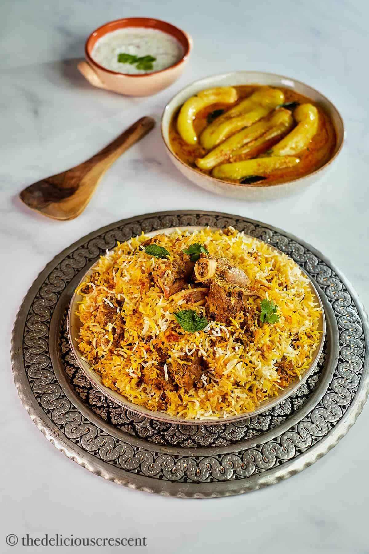 A plate full of lamb biryani served with chili pepper curry.