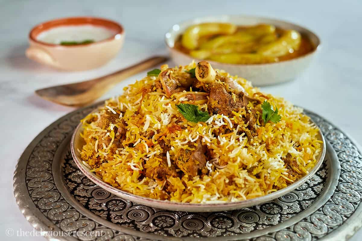 Lamb biryani served with mirchi ka salan and raita.