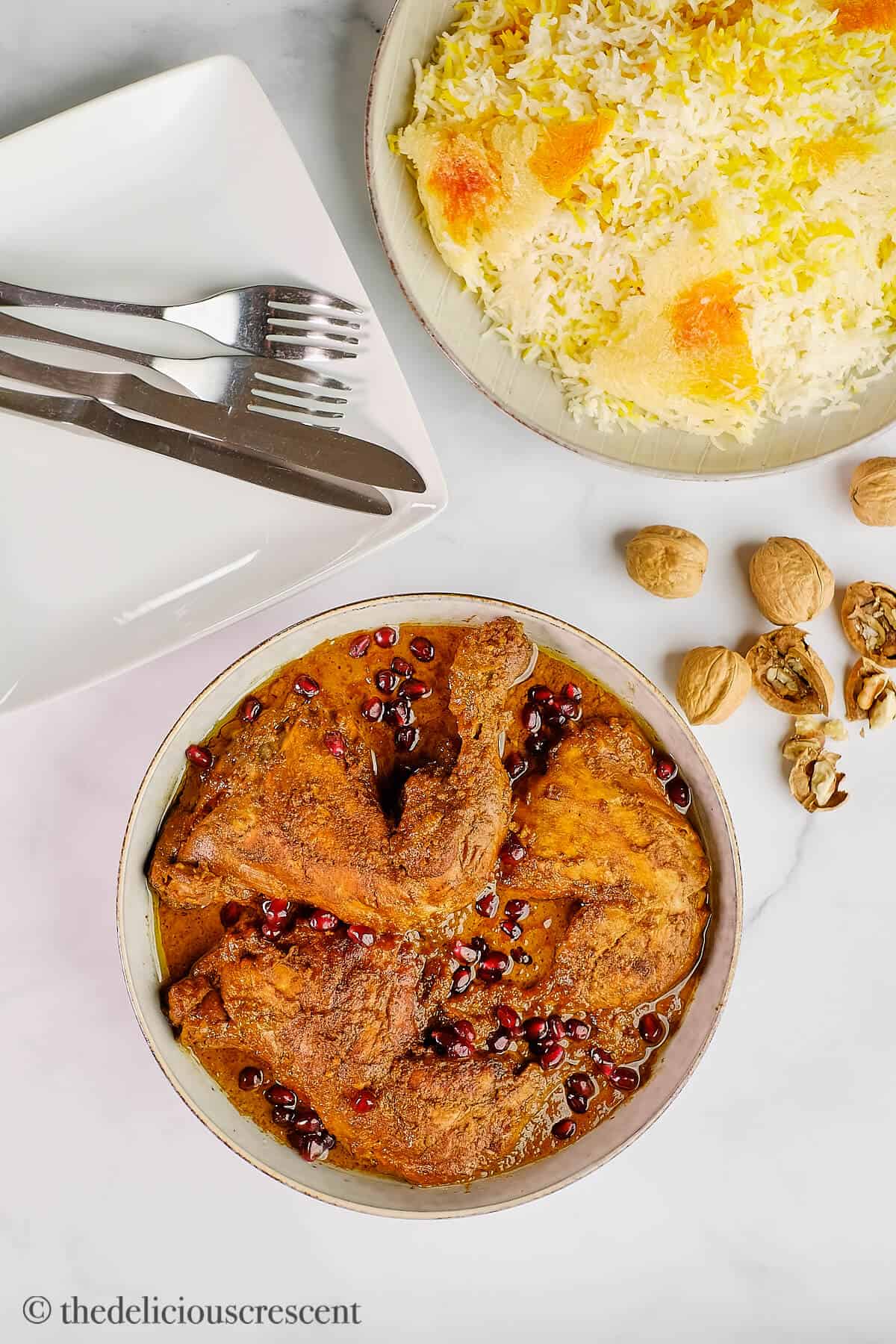 Overhead view of fesenjoon stew served on a table with some steamed rice.