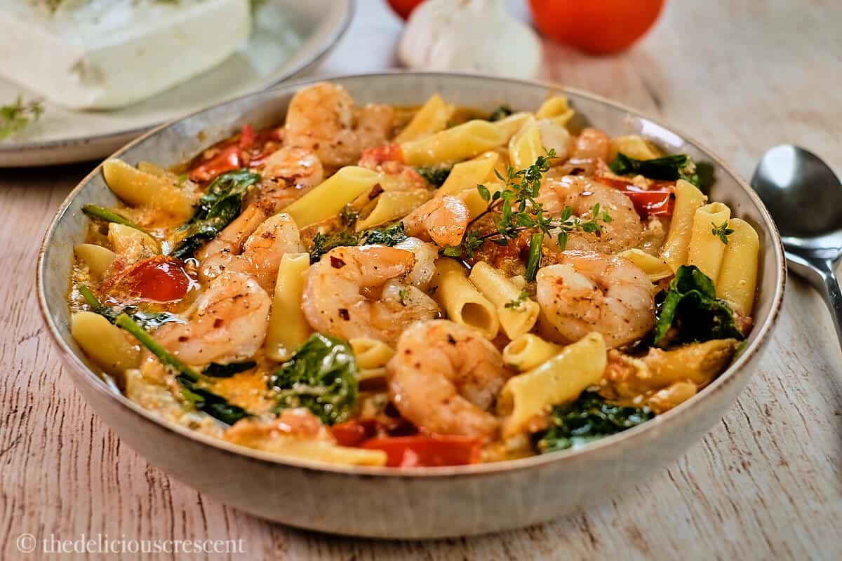 A bowl of shrimp pasta made with feta cheese sauce.