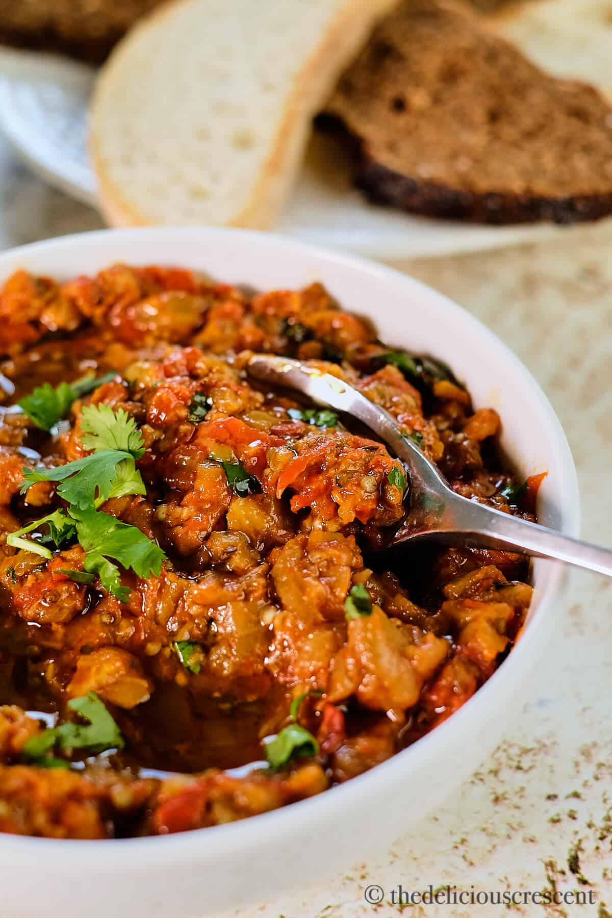 Creamy Moroccan eggplant dip in a bowl with a serving spoon.