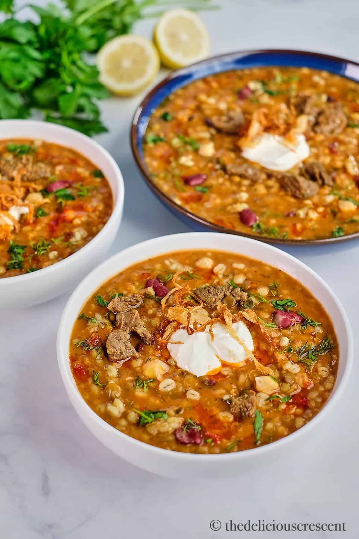 Beef and barley soup prepared in Persian style and served in bowls.