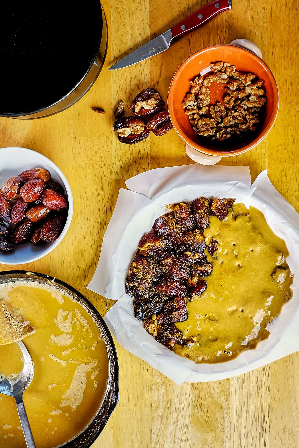 Dates being stuffed with walnuts, layered and toasted flour poured on top.