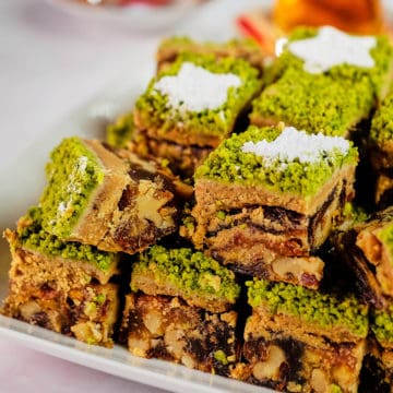 Close up view of Persian date dessert stuffed with walnuts and cut into squares.
