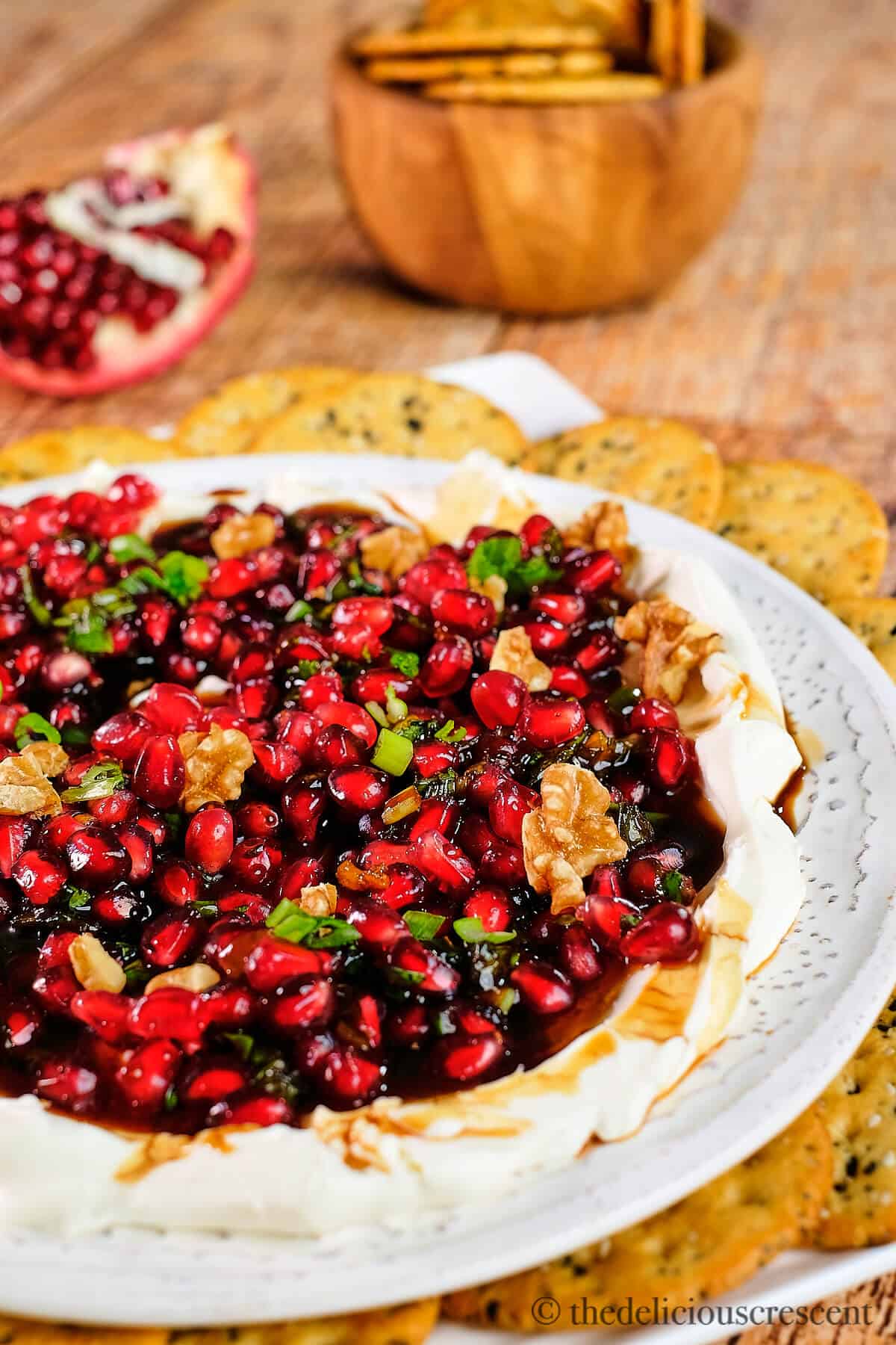 Pomegranate salsa served on cream cheese in a white plate.