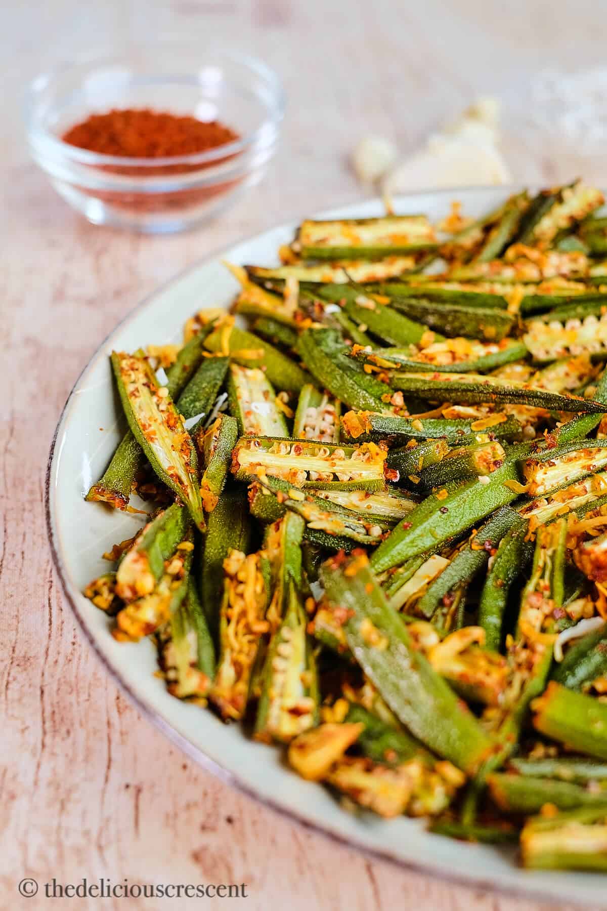 Roasted okra seasoned with spices and served on a plate.