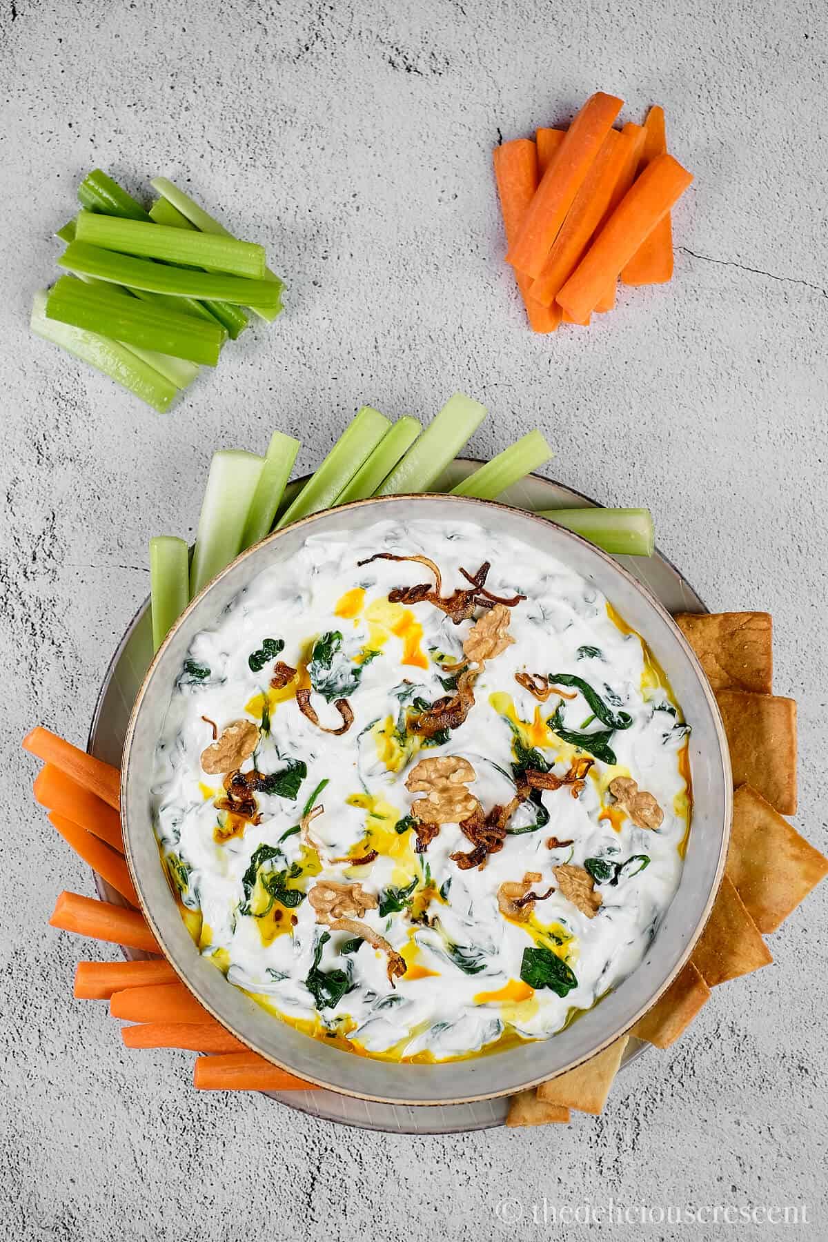 Spinach yogurt dip served with chips and veggies.