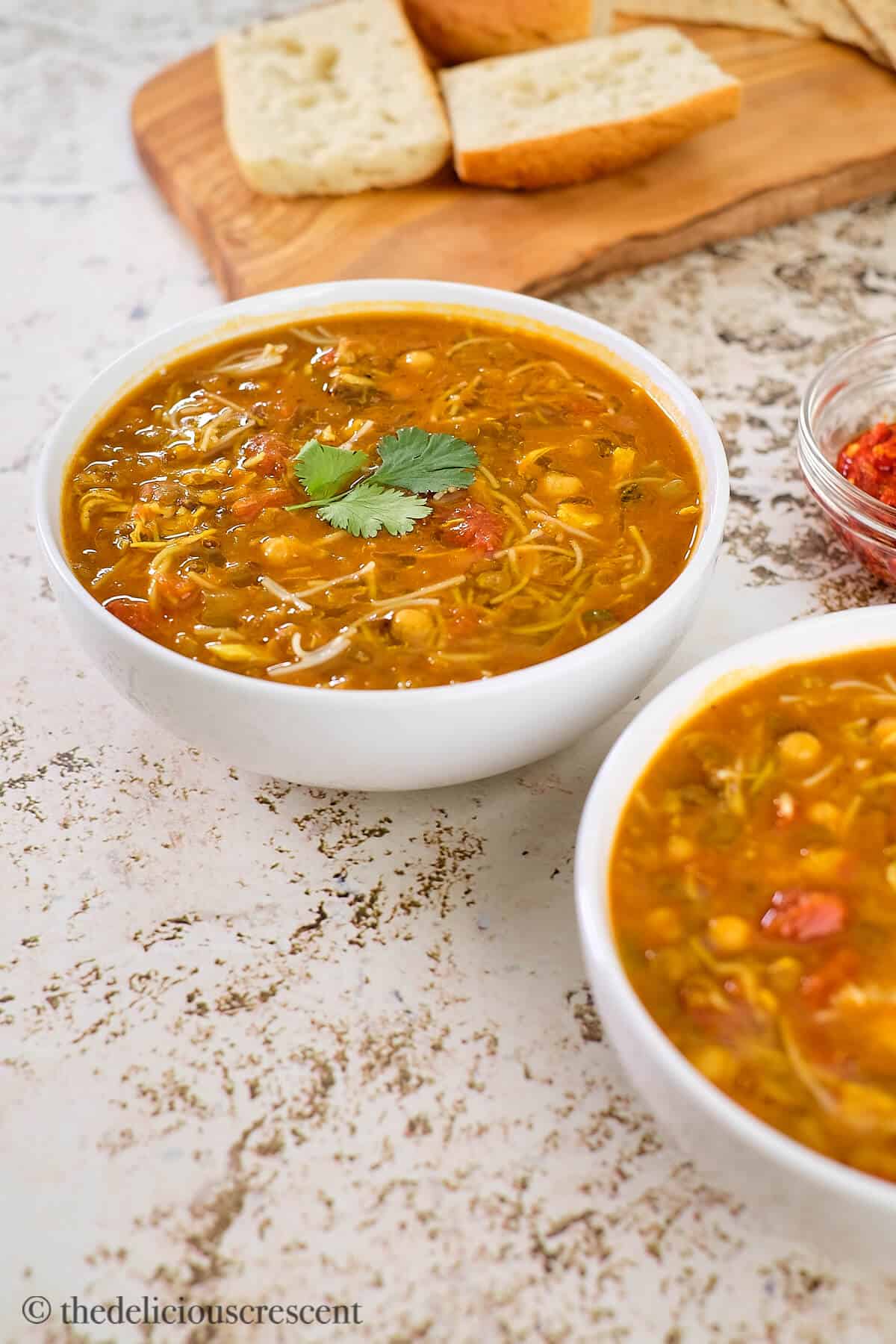 A bowl of thick and creamy soup with bread.