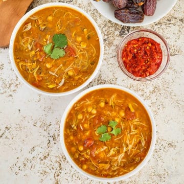 Close view of Moroccan chickpea and lentil soup in bowls placed on a table.