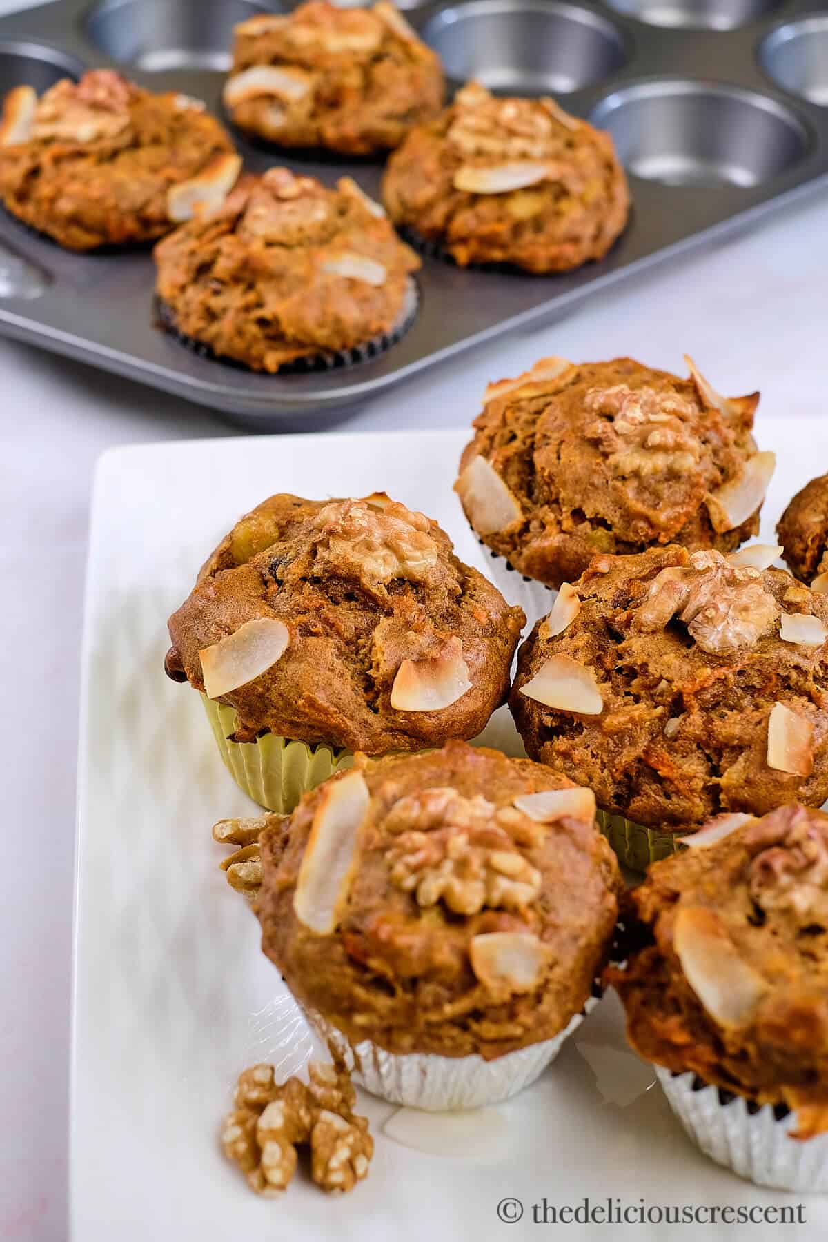 Baked healthy carrot cake muffins on a platter.