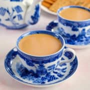 Close up view of spiced tea served in elegant blue and white cups.