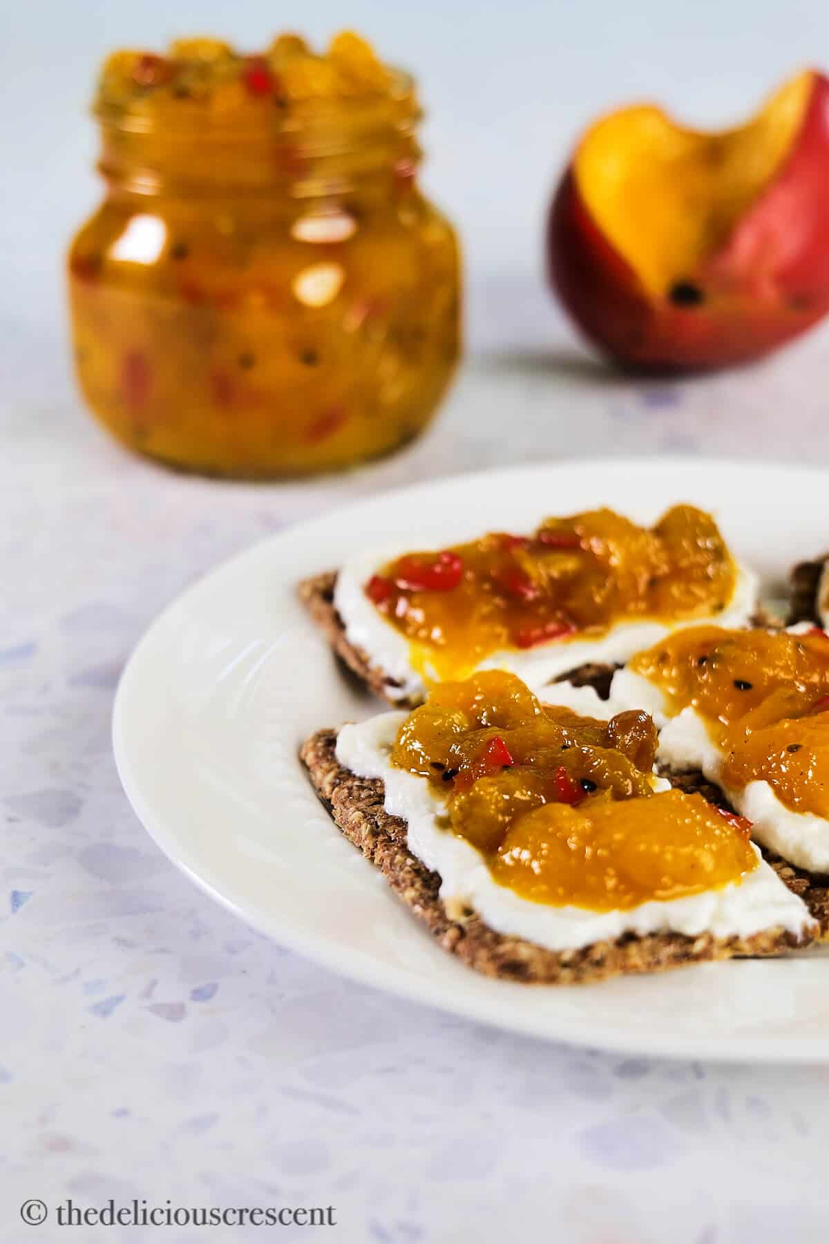 Savory and spicy mango preserves in a bottle and on crackers.