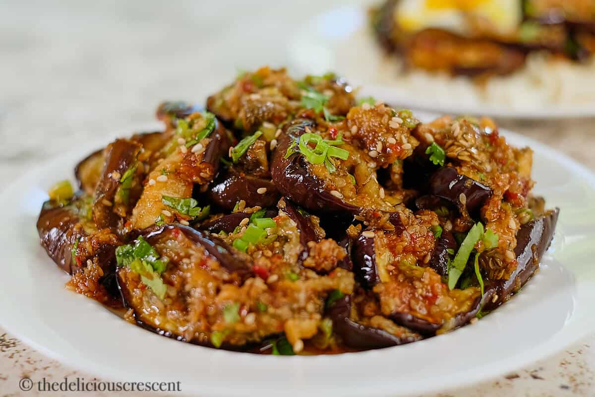 Asian roasted eggplant in a white dish.