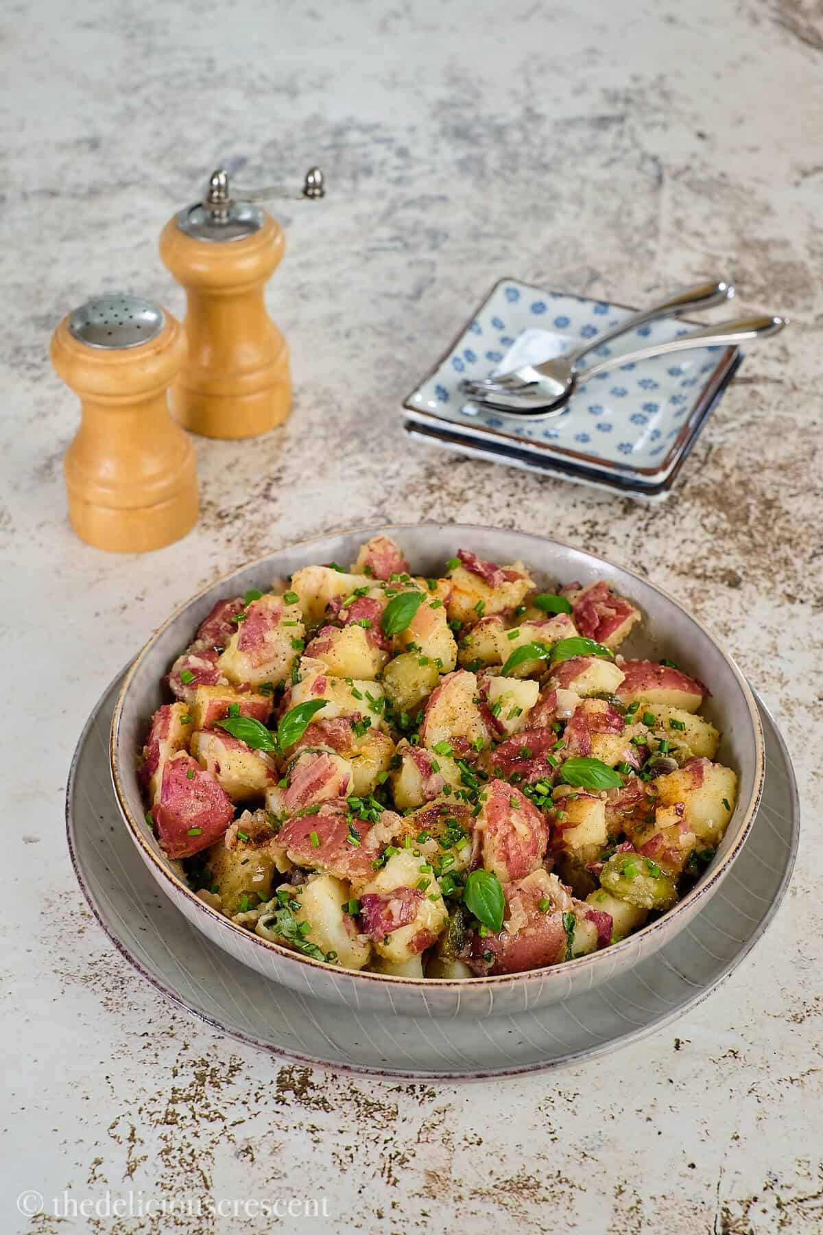 Delicious salad made with potatoes and served in a grey bowl.