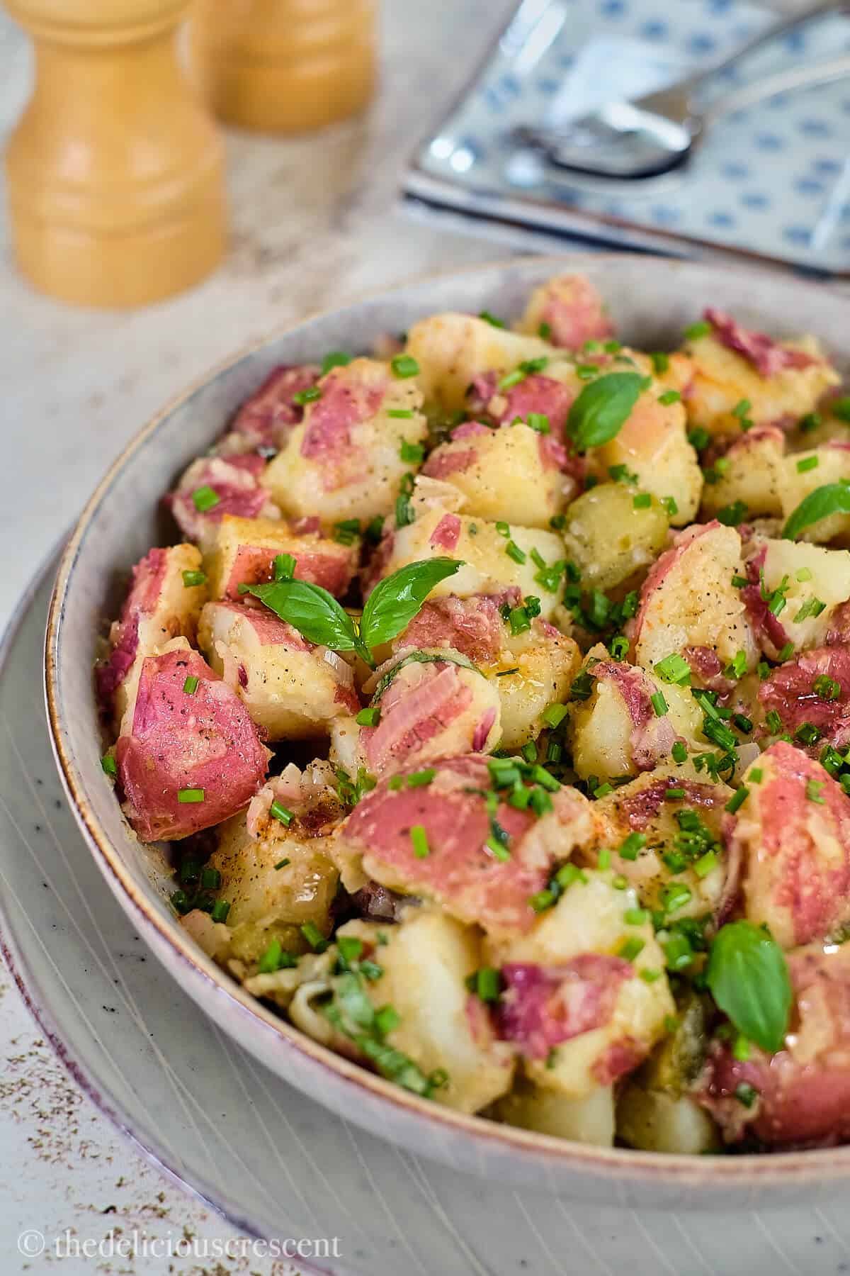Vegan German potato salad in a grey bowl.