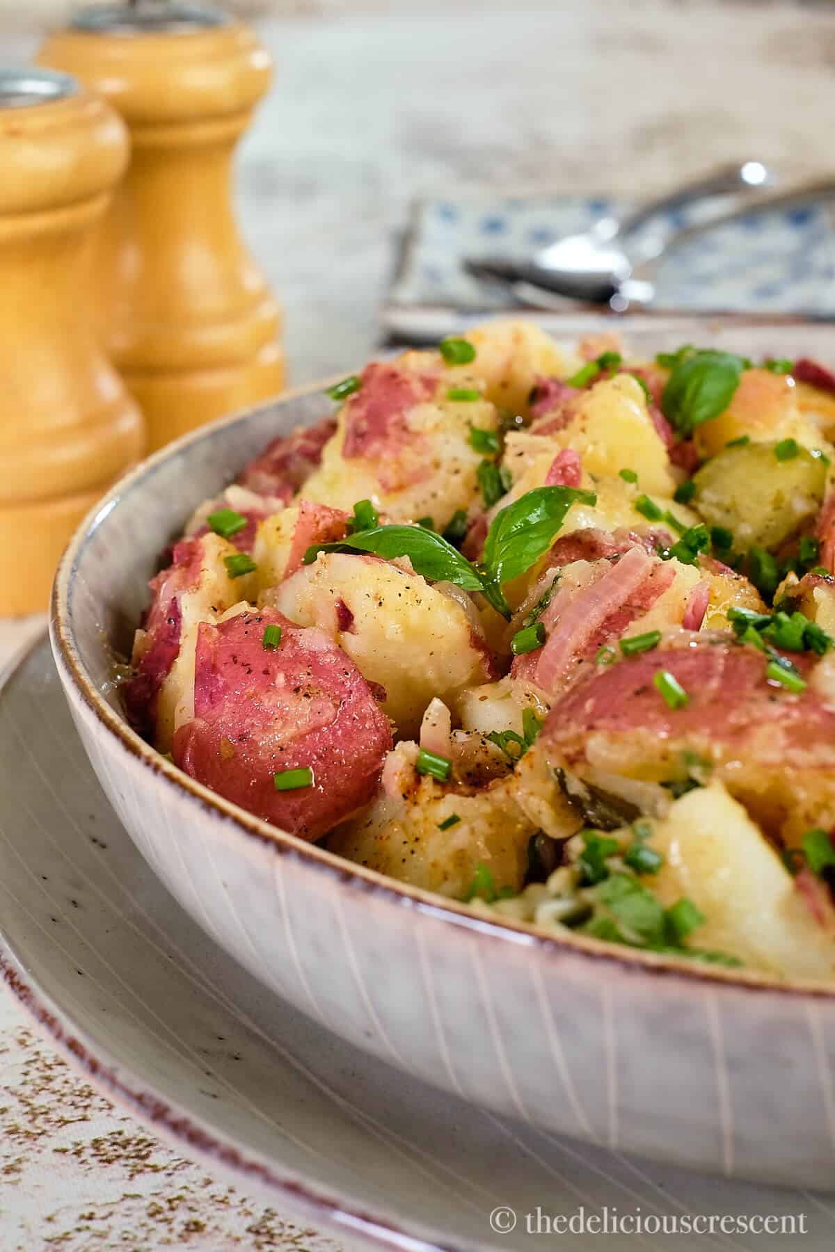 Red potato salad topped with herbs.