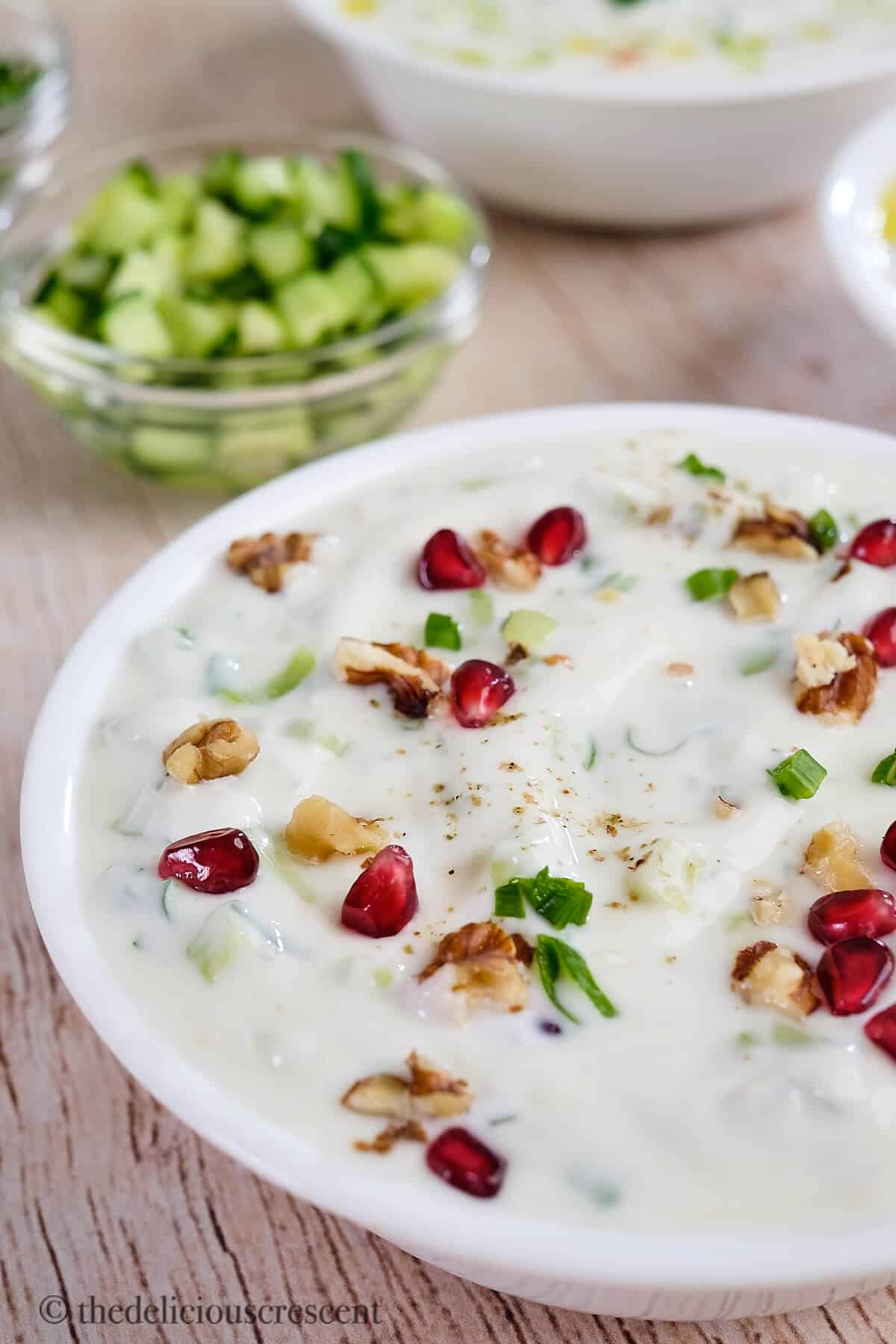 Cucumber yogurt salad topped with pomegranate.