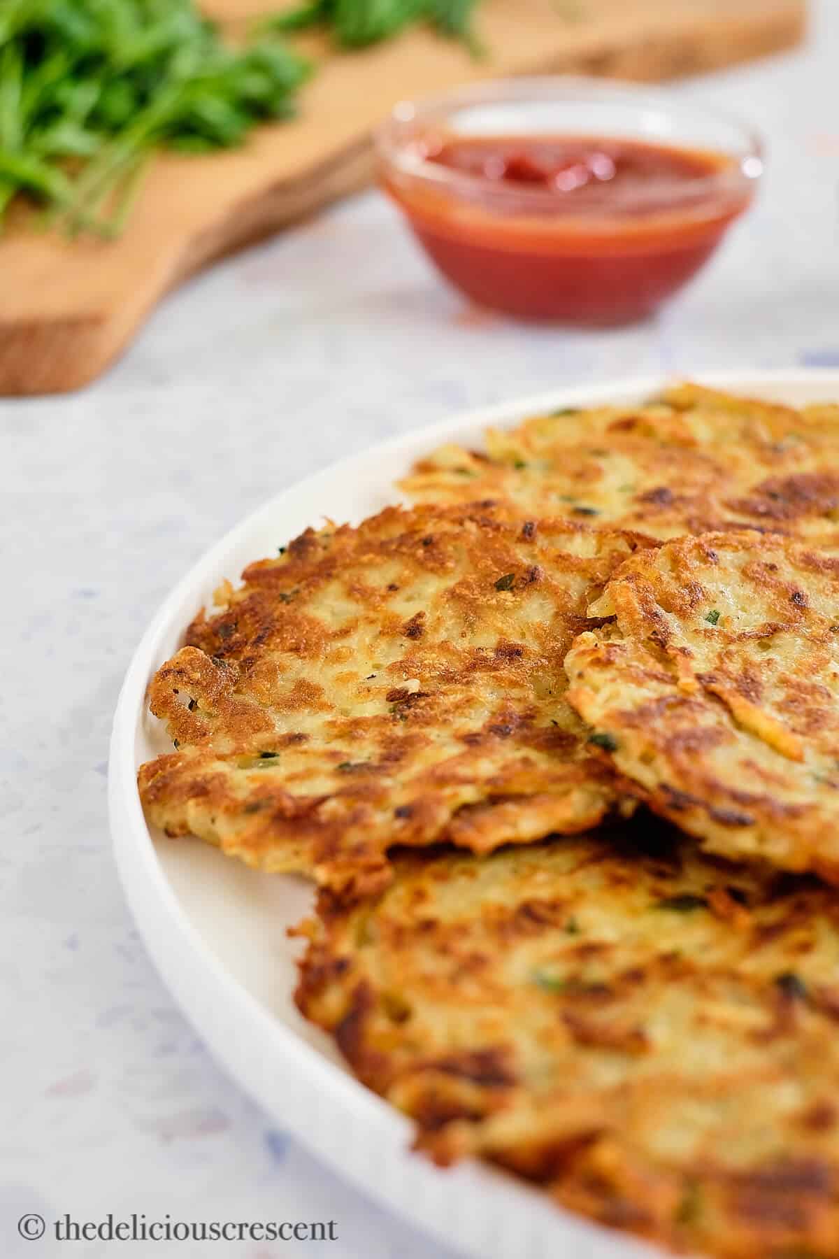 Kartoffelpuffer arranged in a white plate.