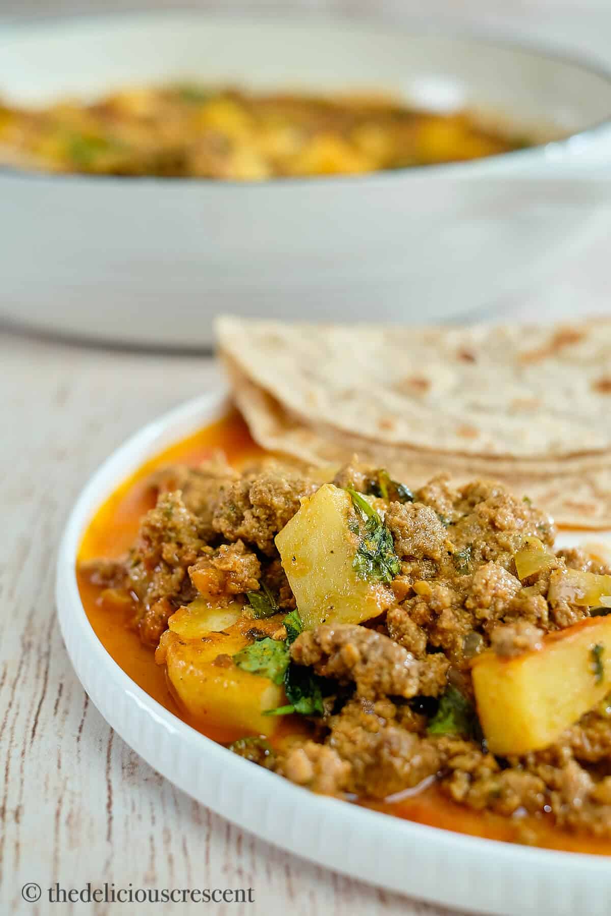 Ground beef curry served with flatbreads in a plate.