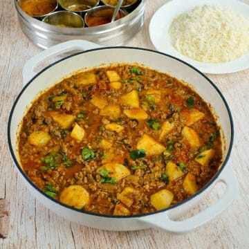 Keema curry with potatoes in a white pan.