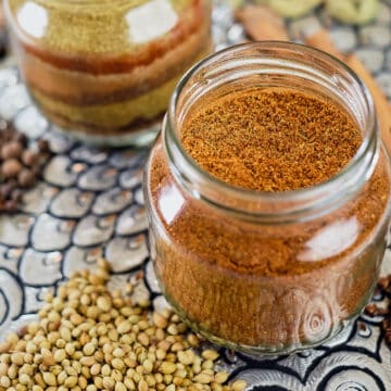 Close view of two bottles of baharat placed on a platter.