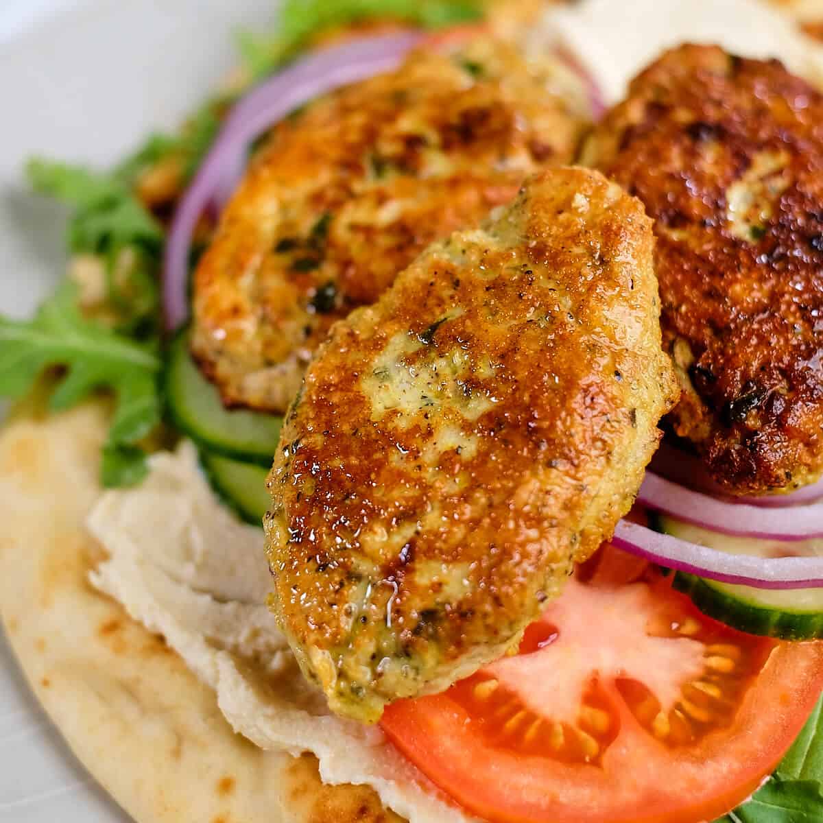 Close up of juicy chicken koftas stacked together.
