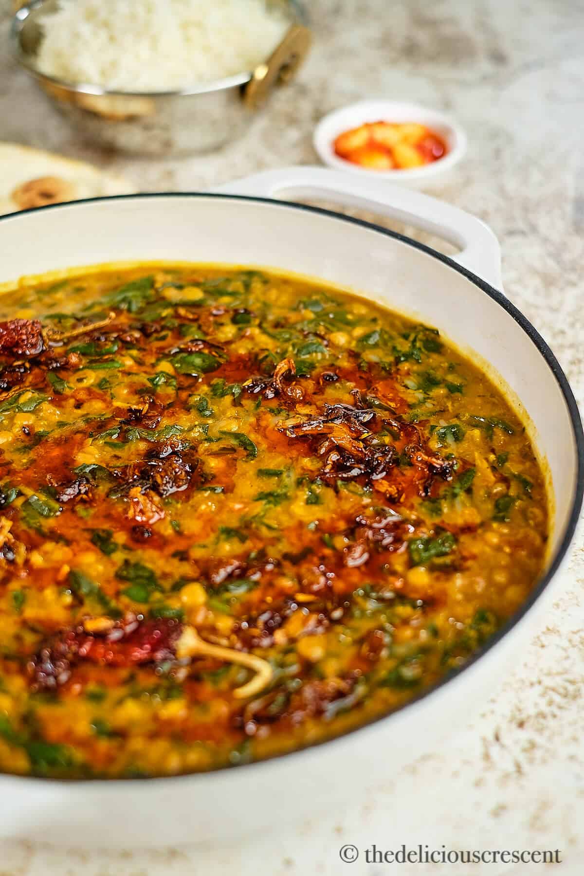 Dal palak cooked and served in a white casserole pot.