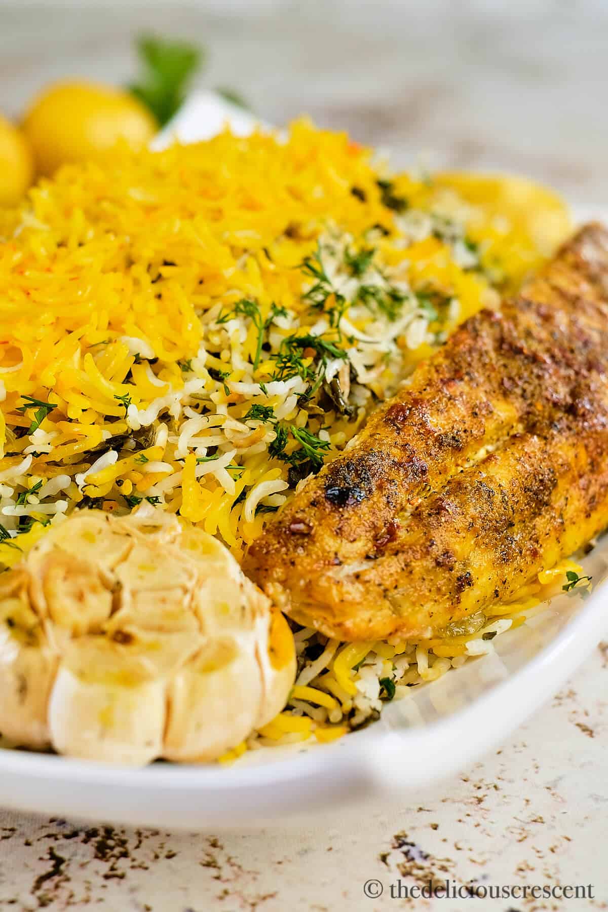 Fish arranged on top of Persian herb rice.