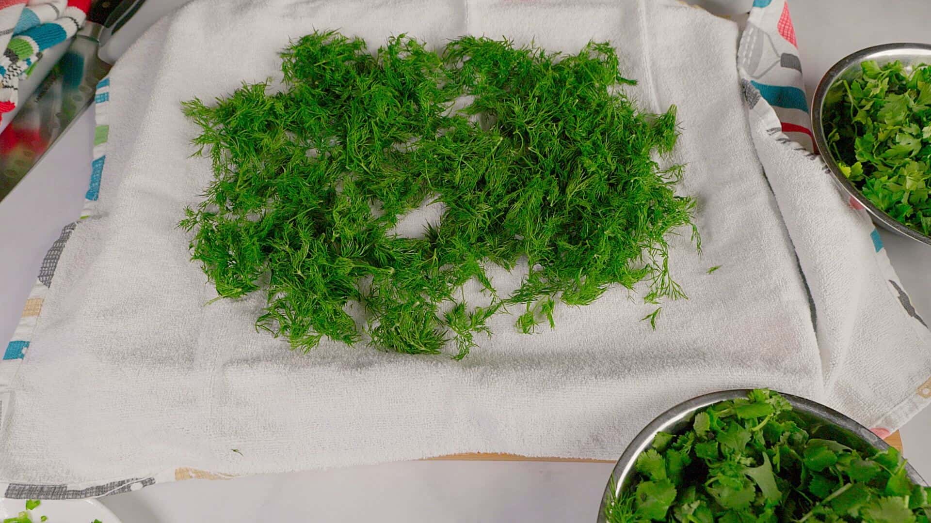 Rinsed herbs spread out on a towel.