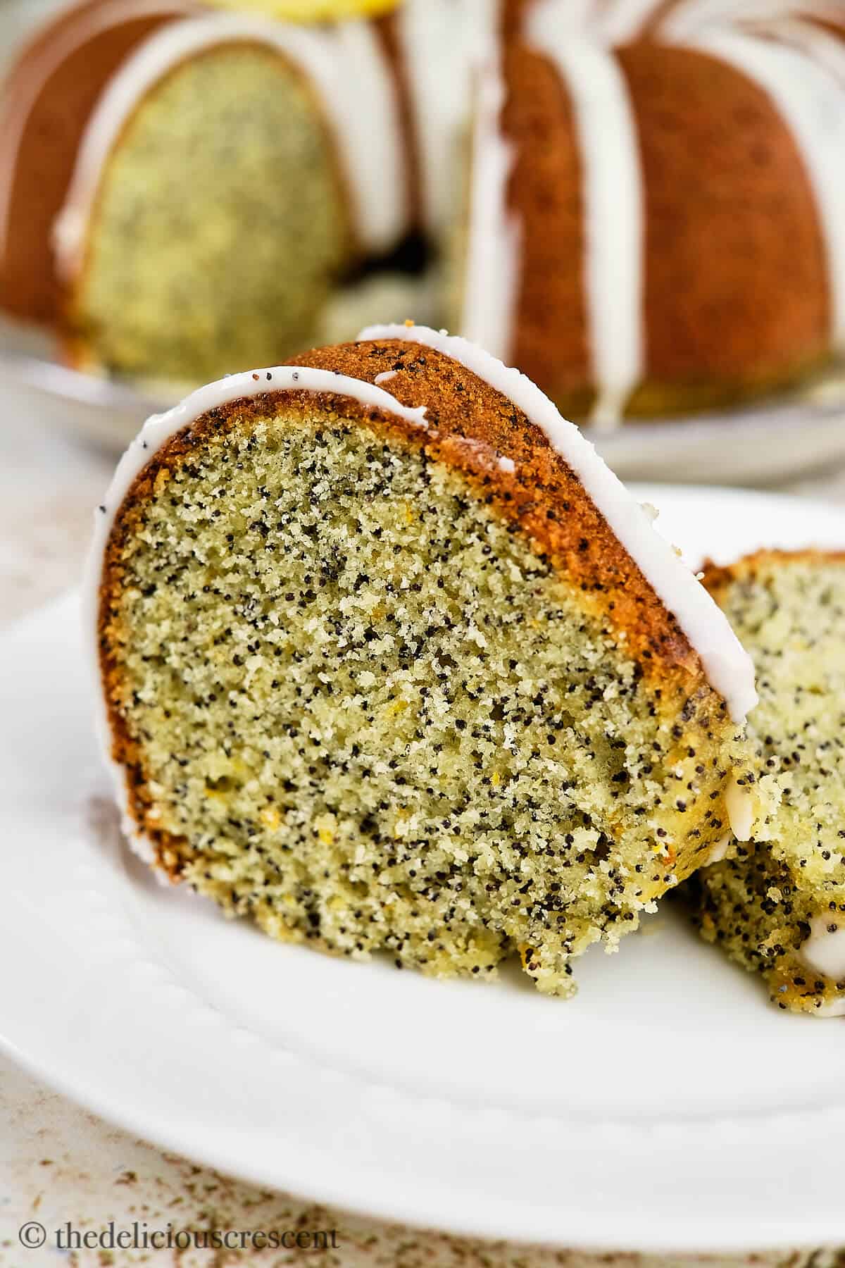 A wedge of citrus cake with poppy seeds.