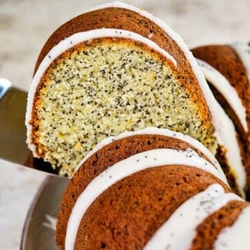 Close view of a slice of lemon poppy seed cake lifted from the plate.