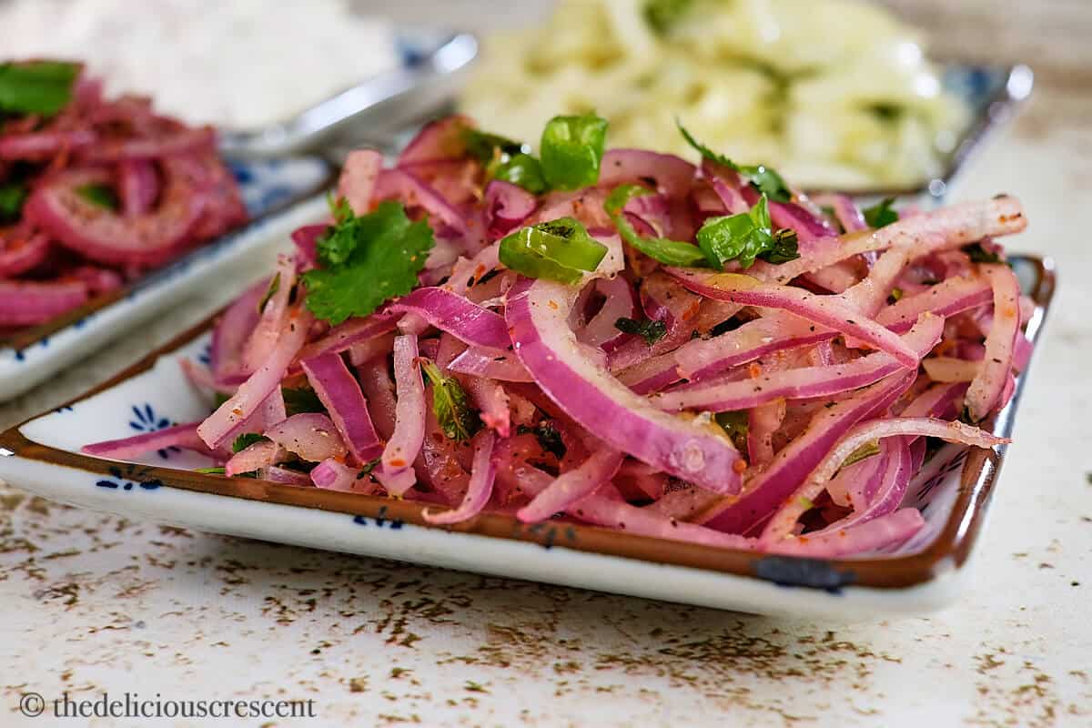 Indian onion salad served in a blue plate.