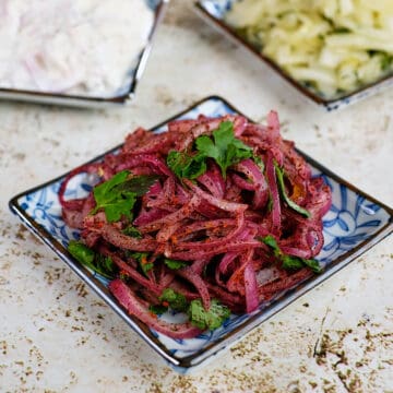 Close view of four different types of onion salads served on a table.