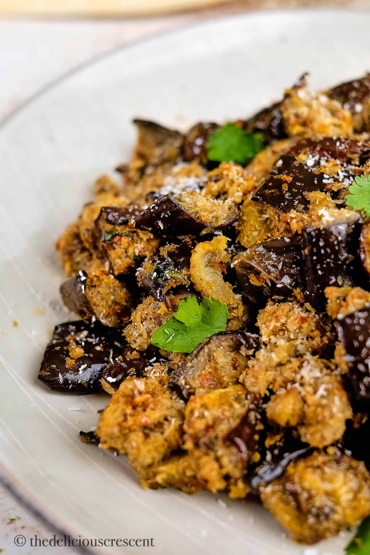 Spicy eggplant side dish served in a white plate.