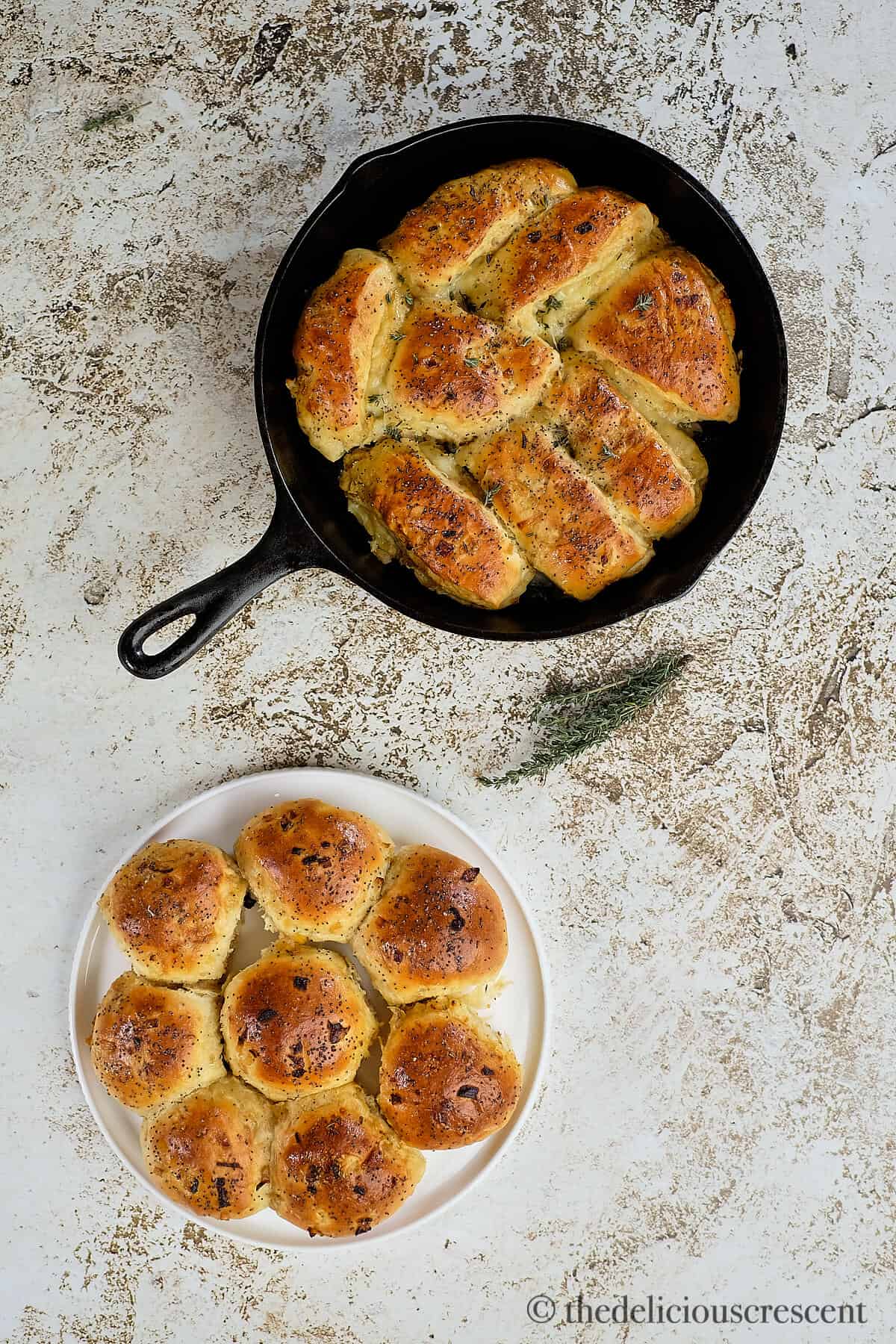 Two kinds of onion bread rolls on a table.