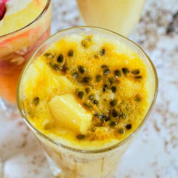 Close view of peach passion fruit smoothie in a glass.