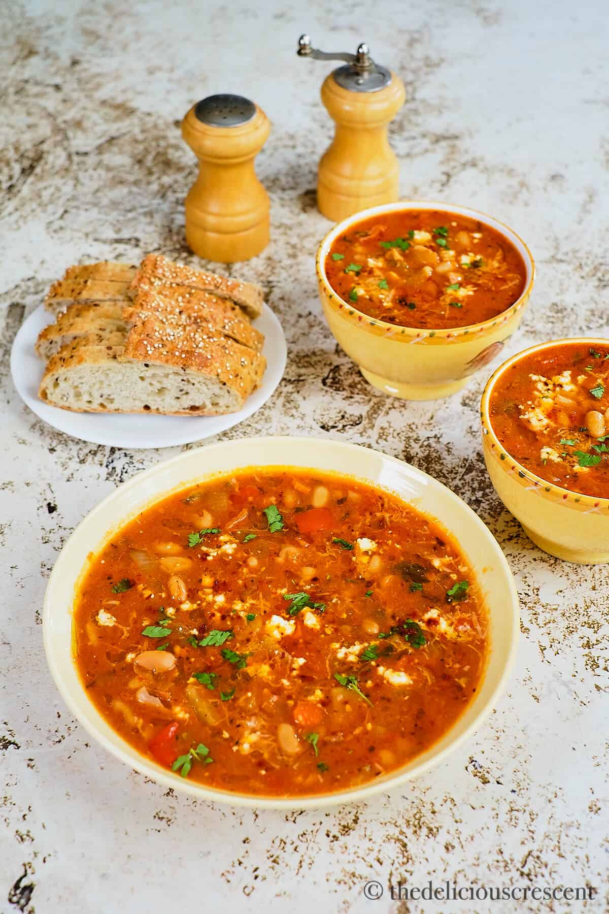 Rich bean soup with vegetables and bread on the table.