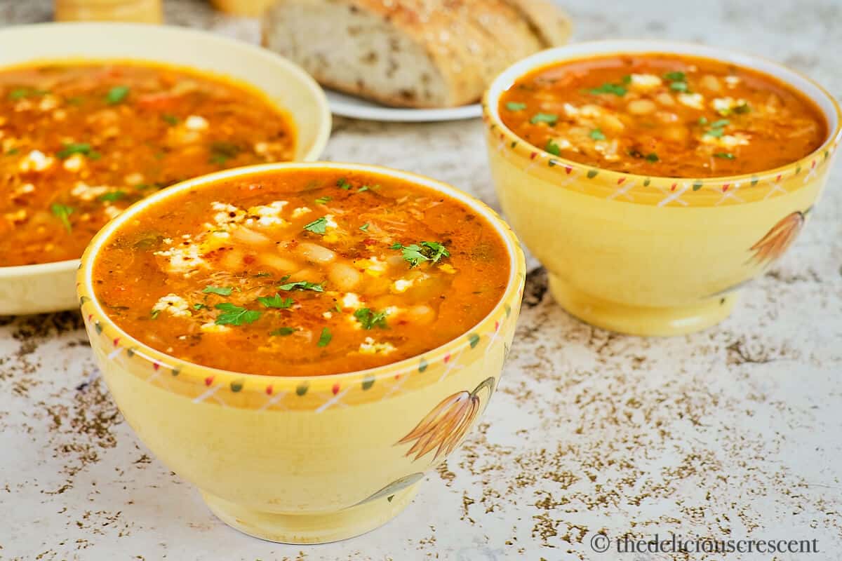 Mediterranean white bean soup served in yellow bowls.