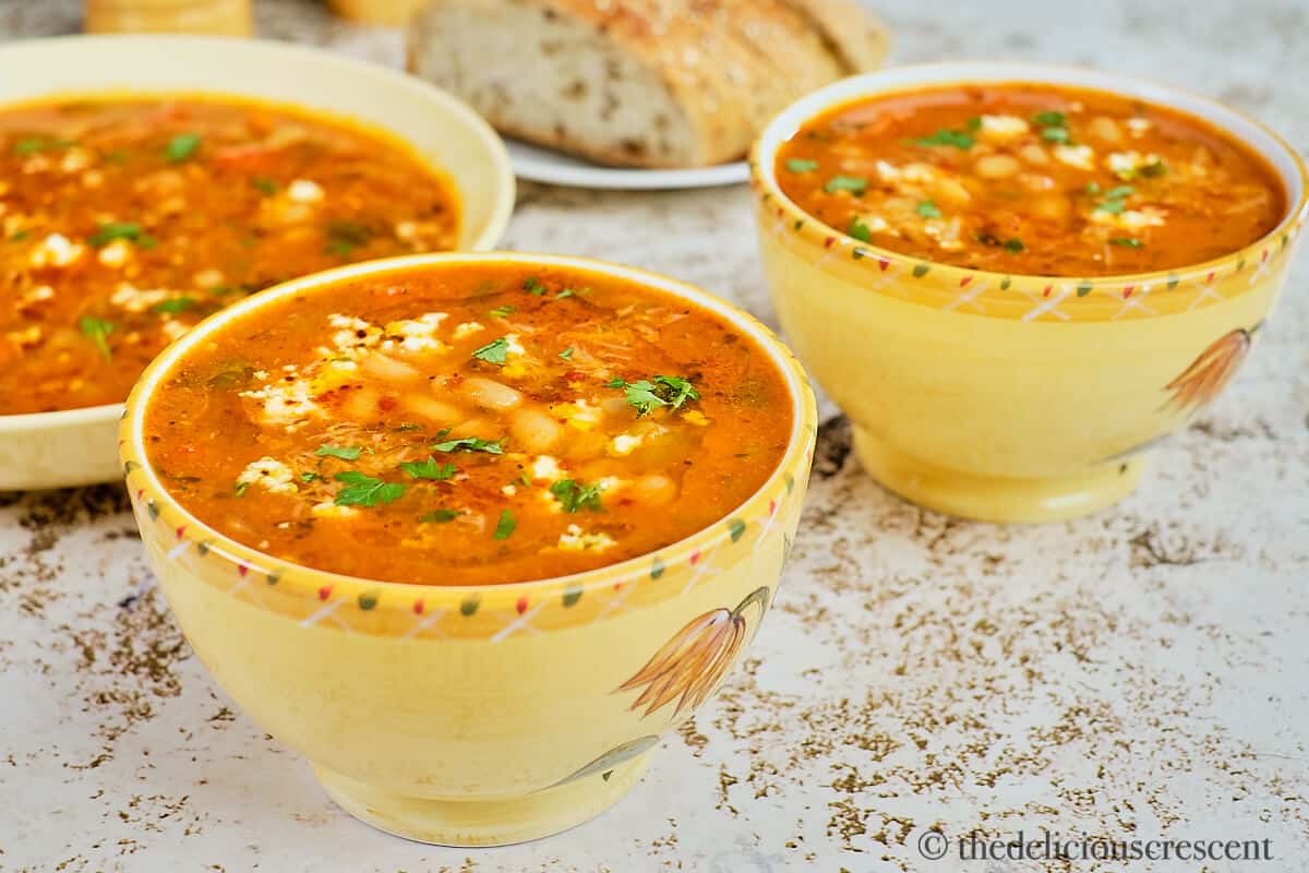 Mediterranean white bean soup served in yellow bowls.