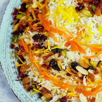 Close view of Persian jeweled rice served in a light blue plate.