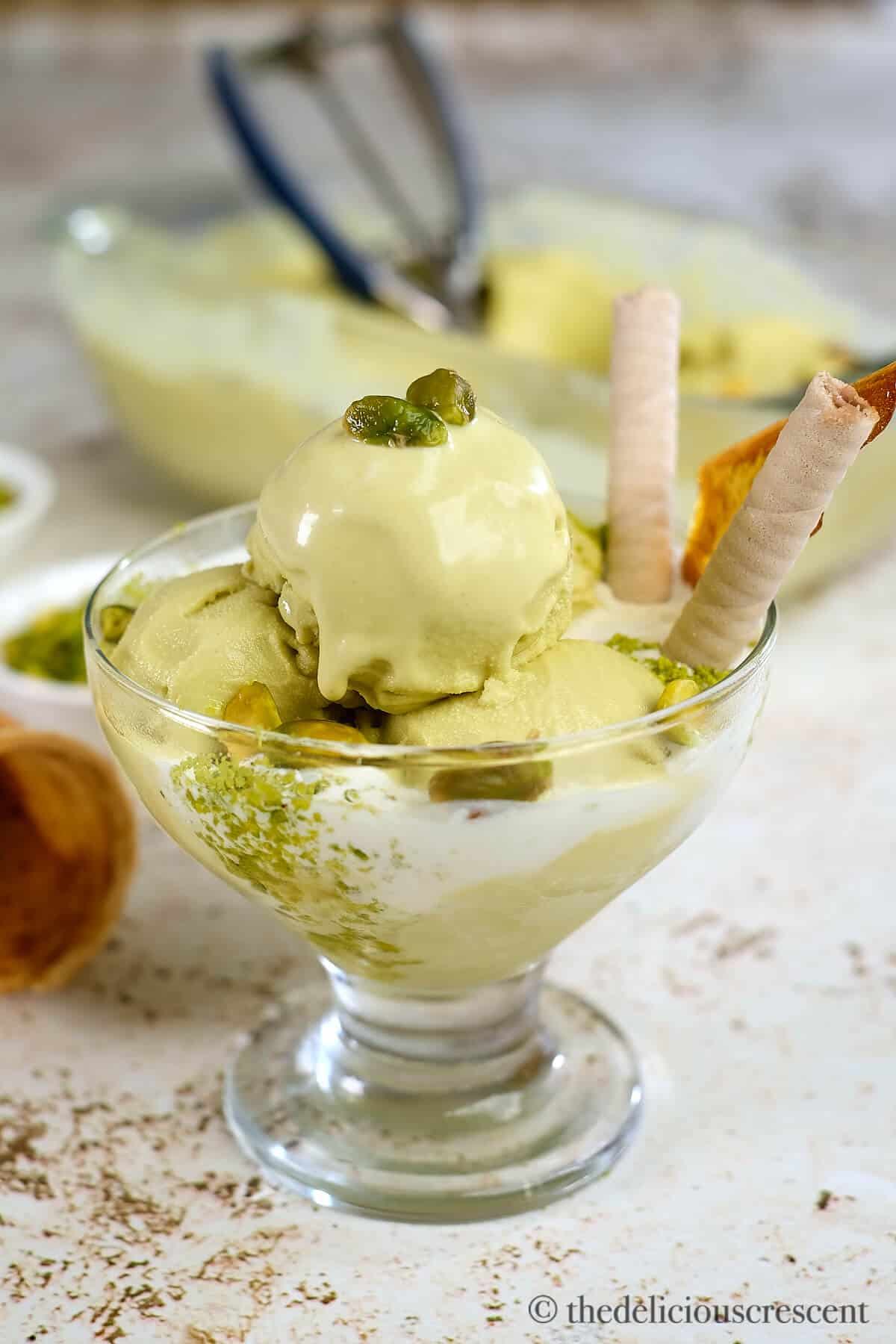 Creamy pistachio gelato served in a glass cup.