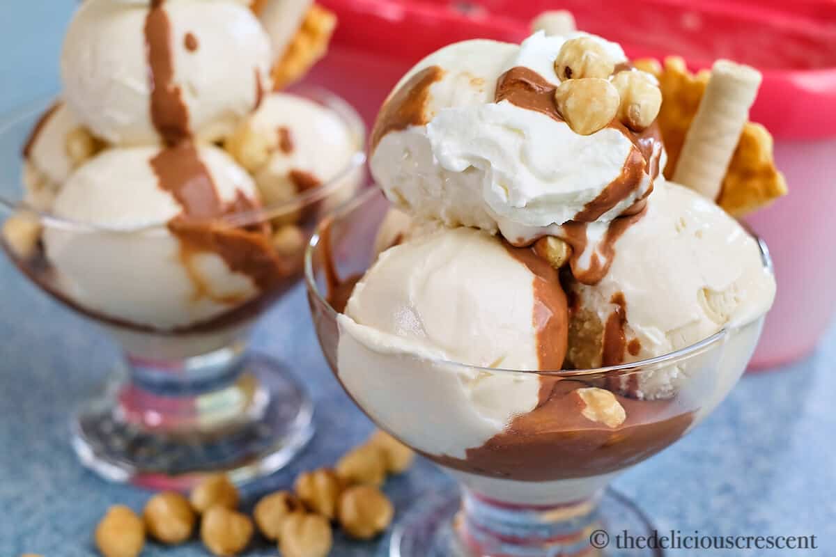 Hazelnut gelato topped with chocolate sauce and nuts.