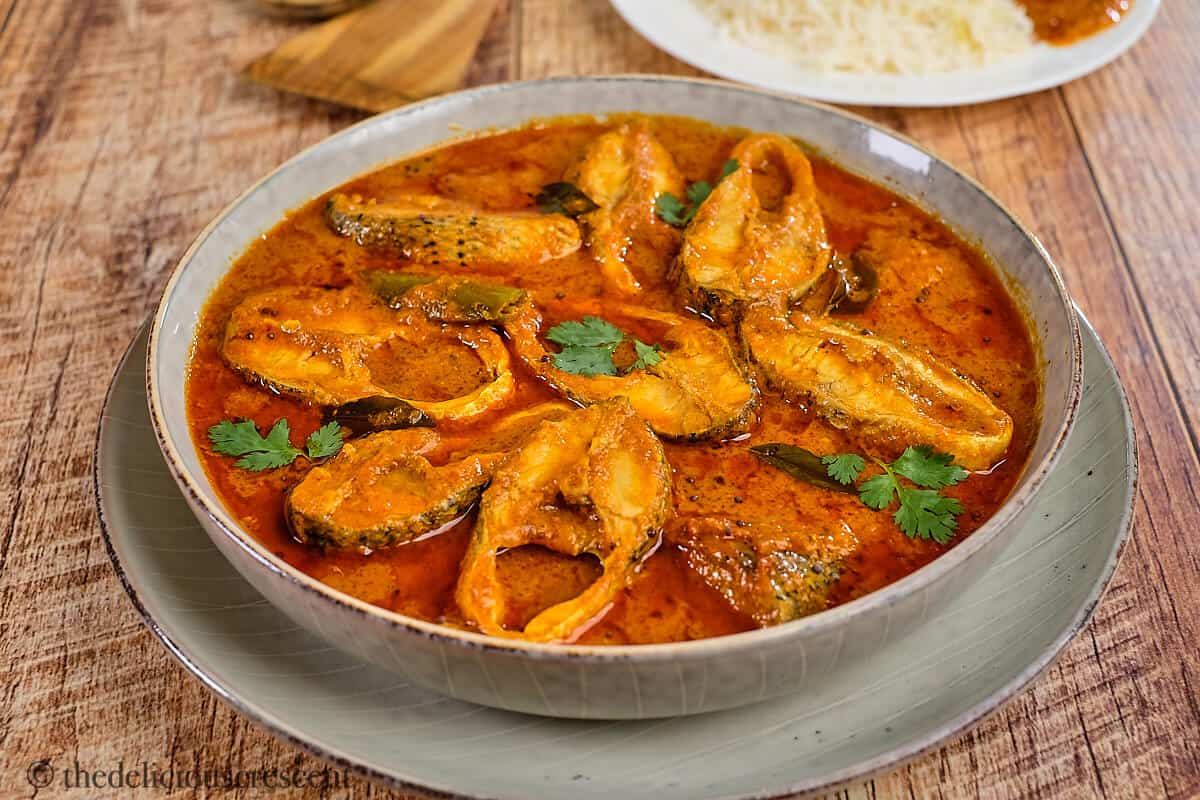 Fish curry served with rice on a table.