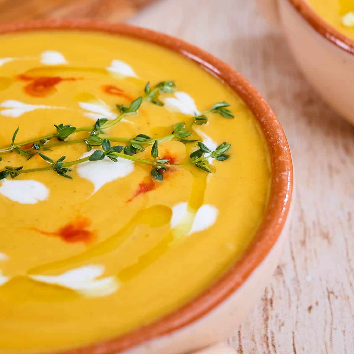 Close view of a bowl of spiced butternut squash soup on a table.