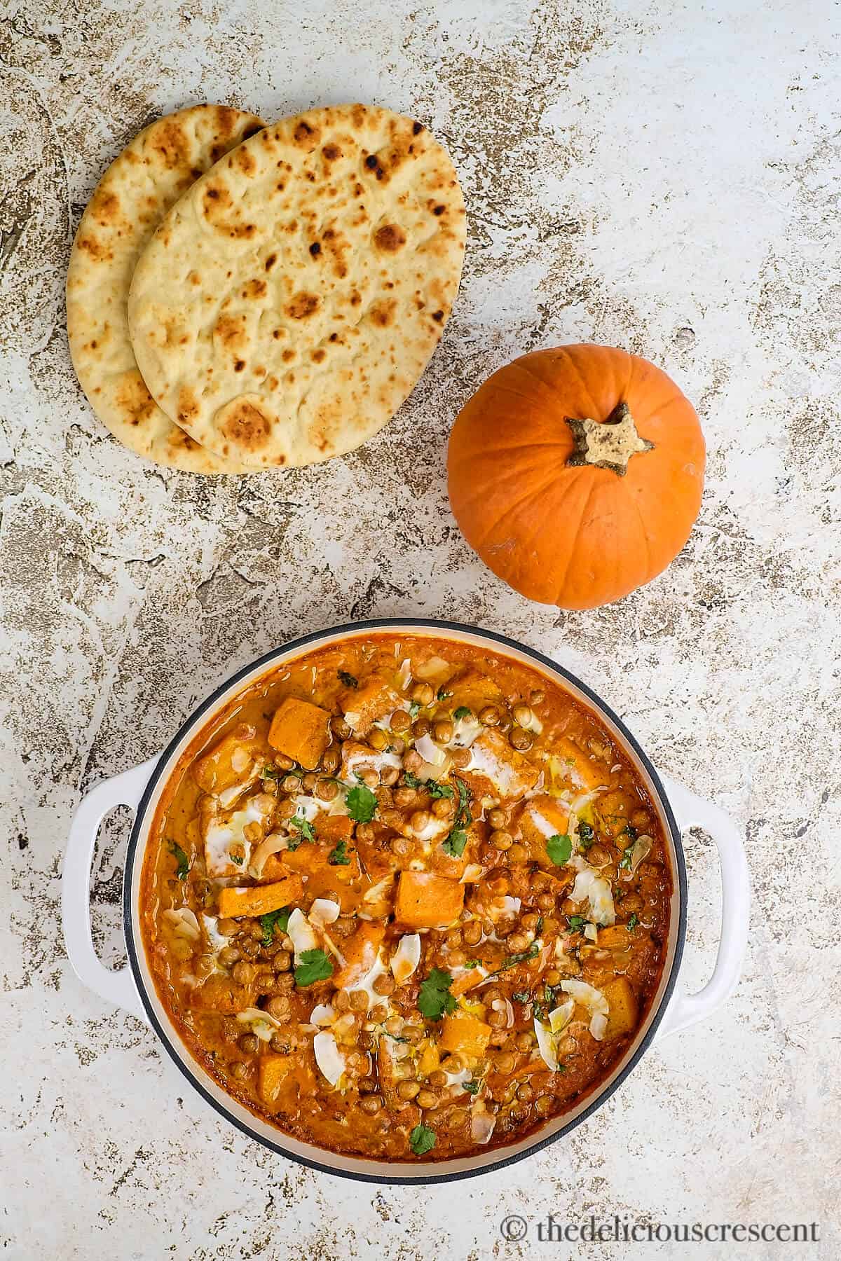Overhead view of pumpkin coconut curry and naan.