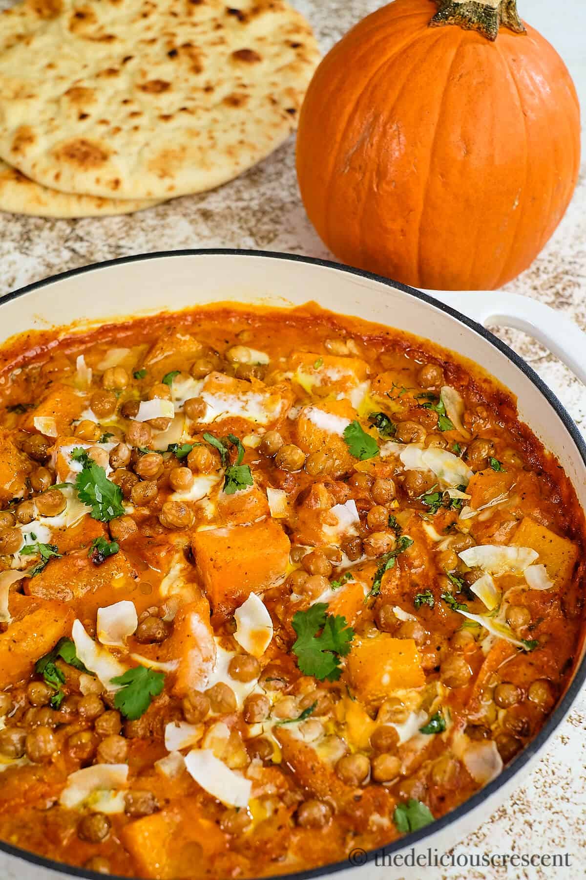 Pumpkin curry with chickpeas and coconut served in a casserole dish.