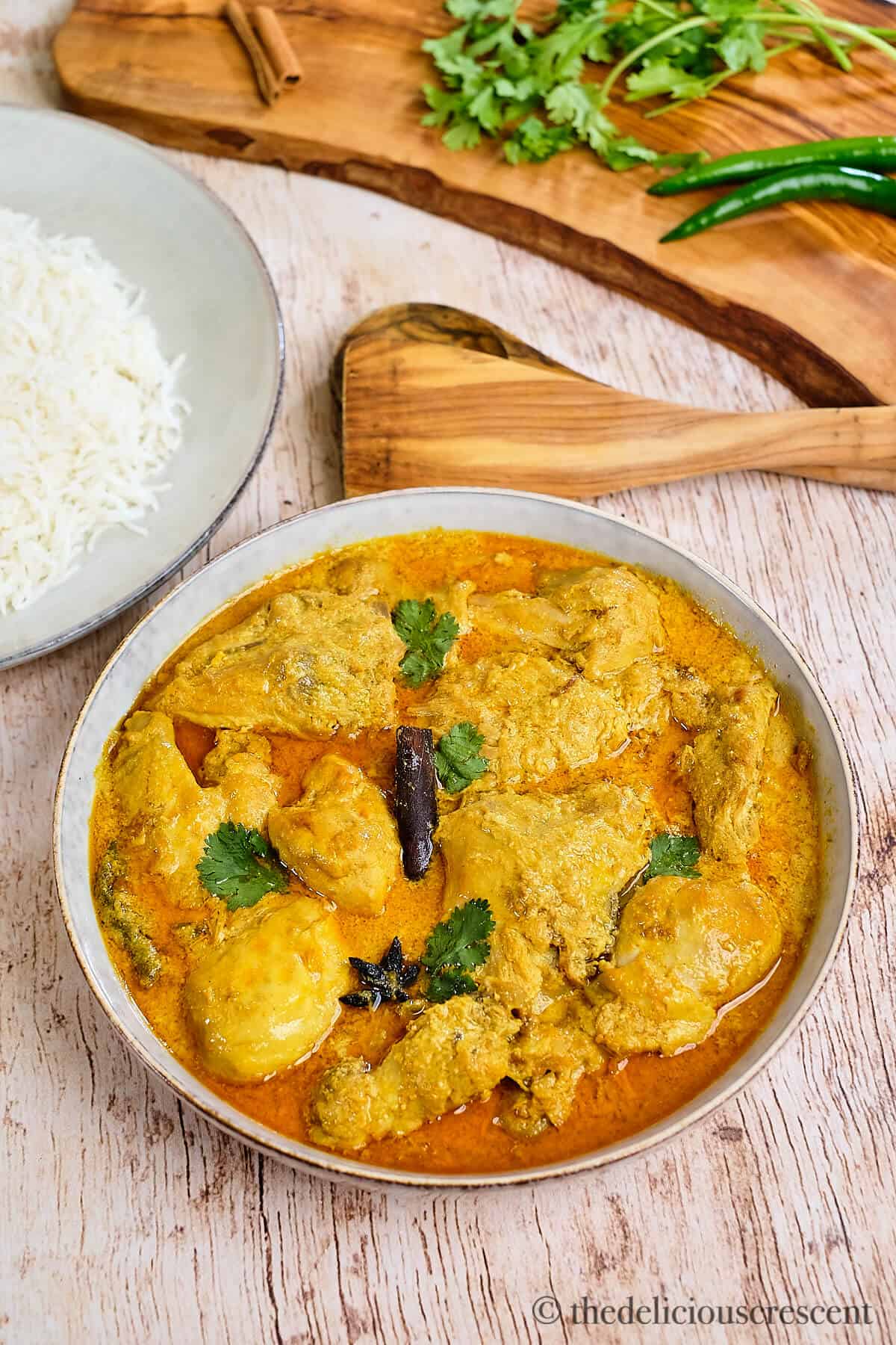 Indian coconut chicken stew served with steamed rice on a table.